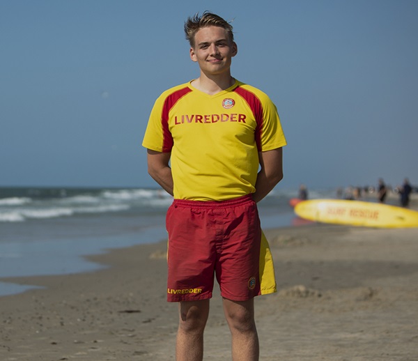 Livredder på stranden med ryggen til