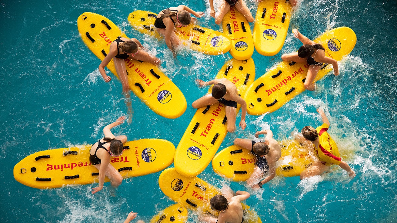 En gruppe på redningssurfbræt i svømmehallen